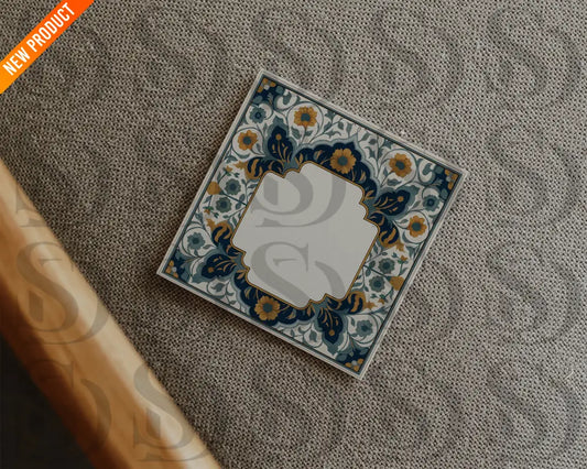 Square wedding card with midnight blue and gold Mughal floral frame placed on a textured fabric surface in a flatlay style.